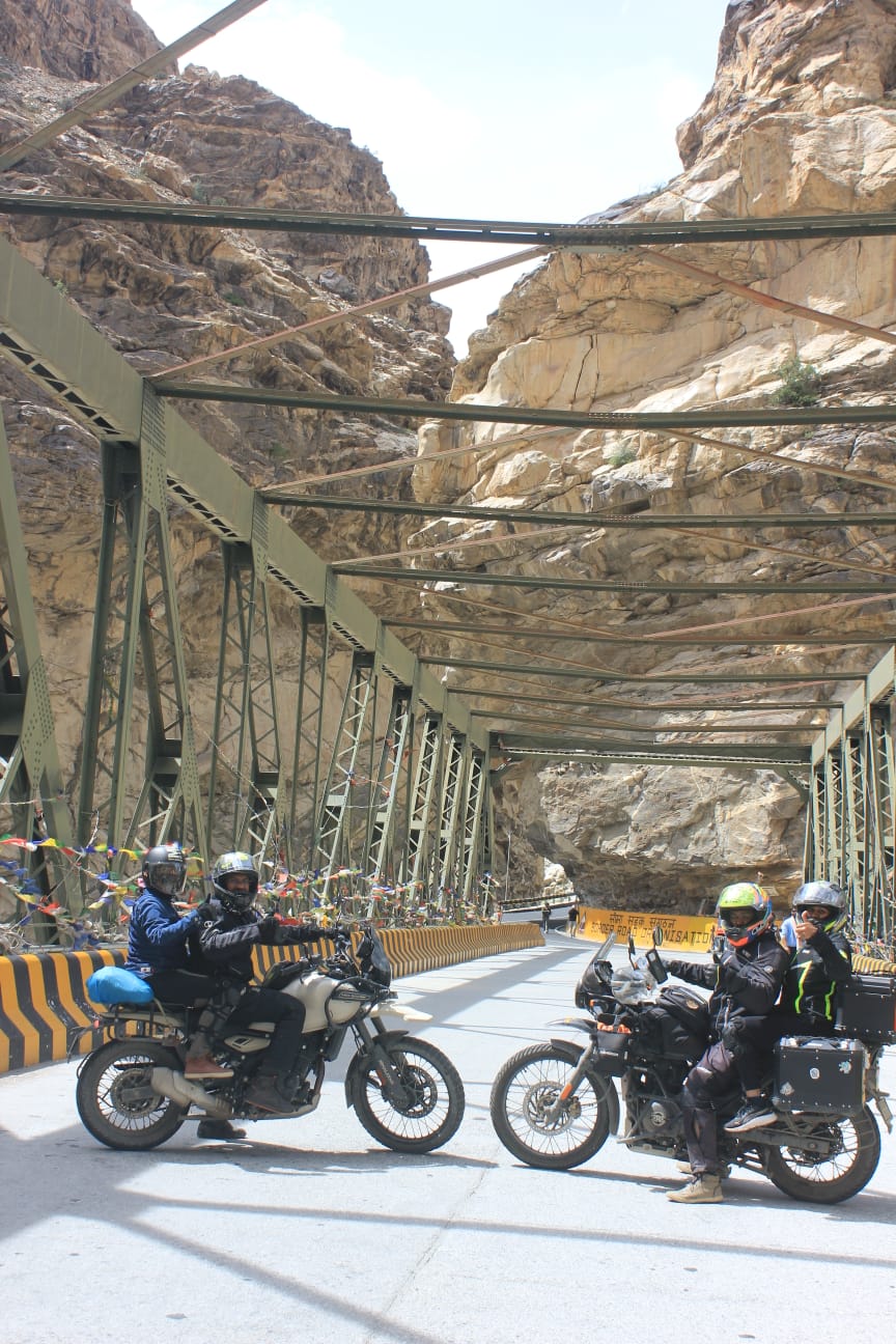 Riders crossing a steel bridge in the Spiti-Kinnaur gorge
